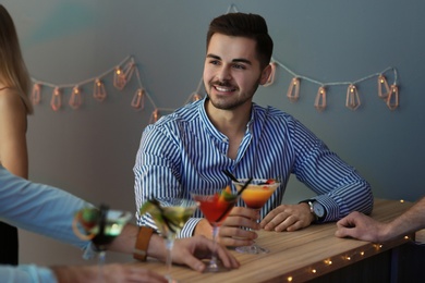 Photo of Young man with martini cocktails in bar