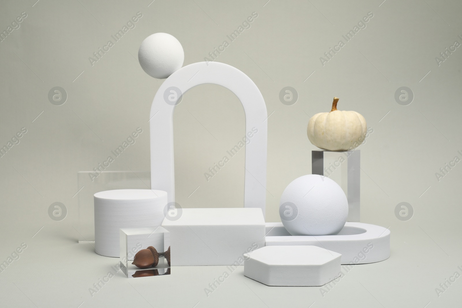 Photo of Autumn presentation for product. Geometric figures, pumpkins and acorn on light grey background