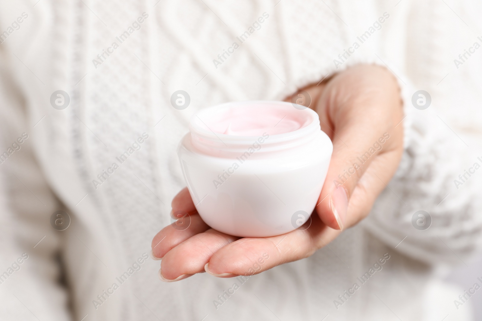 Photo of Woman holding jar of moisturizing cream, closeup. Winter skin care cosmetic