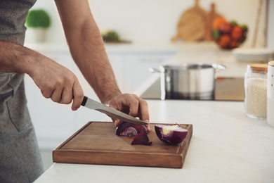 Photo of Man cooking at counter in kitchen, closeup