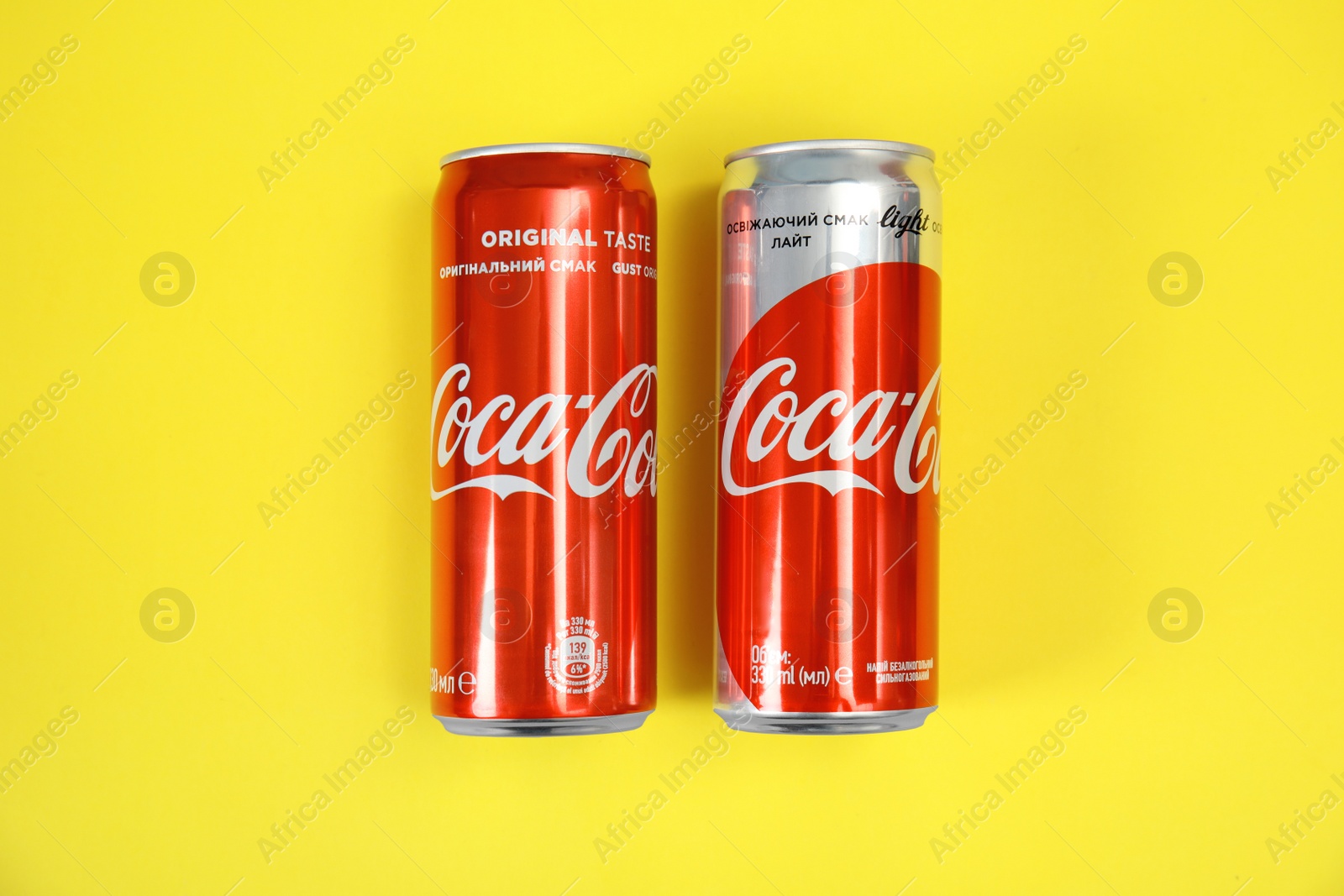 Photo of MYKOLAIV, UKRAINE - NOVEMBER 14, 2018: Coca-Cola cans on color background, top view