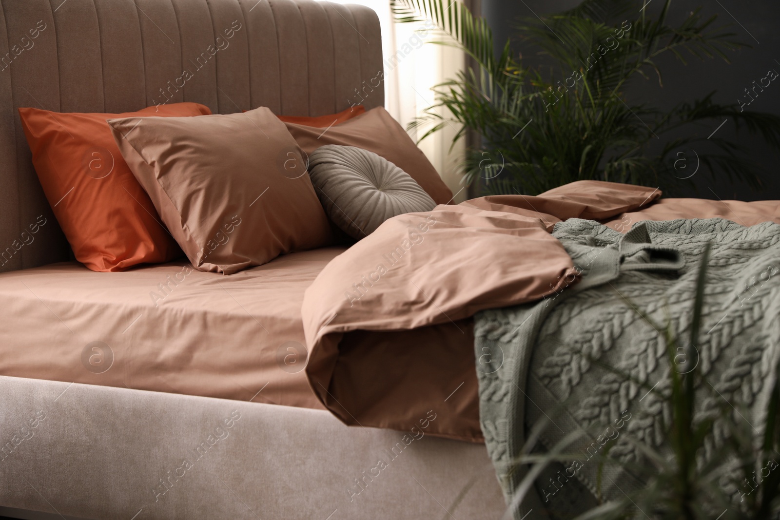 Photo of Bed with stylish cotton linens in room