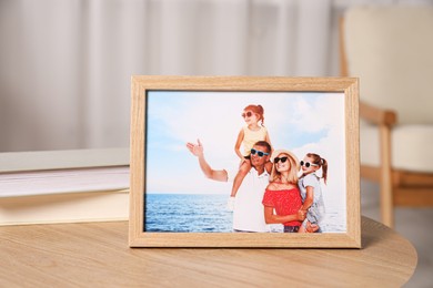 Photo of Pleasant memories. Wooden photo frame with family portrait on table indoors, closeup. Space for text