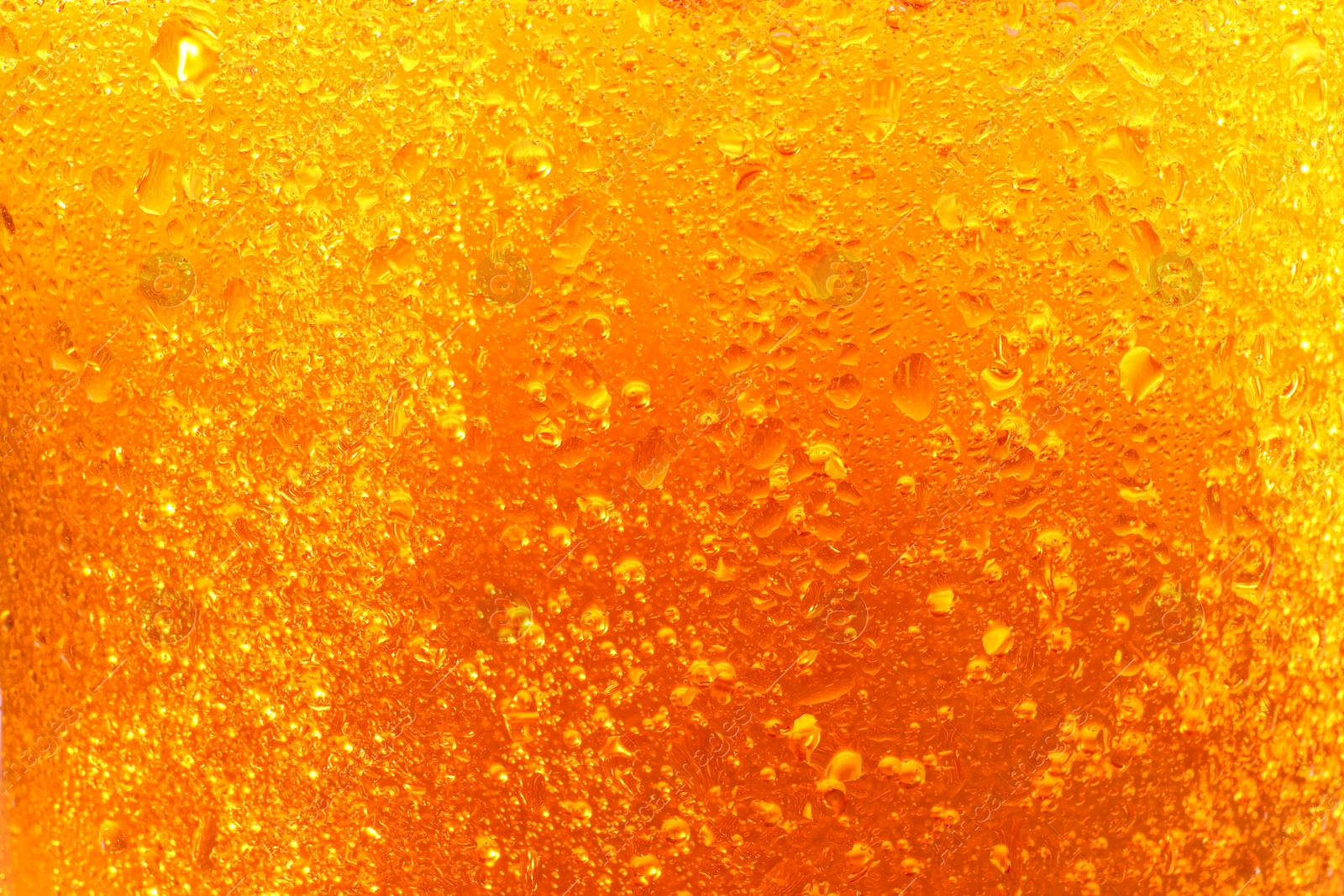 Photo of Glass of tasty cold beer with condensation drops as background, closeup