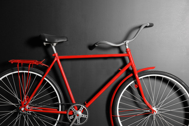 Photo of Red bicycle hanging on black wall, closeup