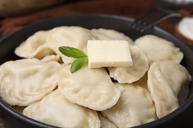 Serving pan of delicious dumplings (varenyky) on table, closeup
