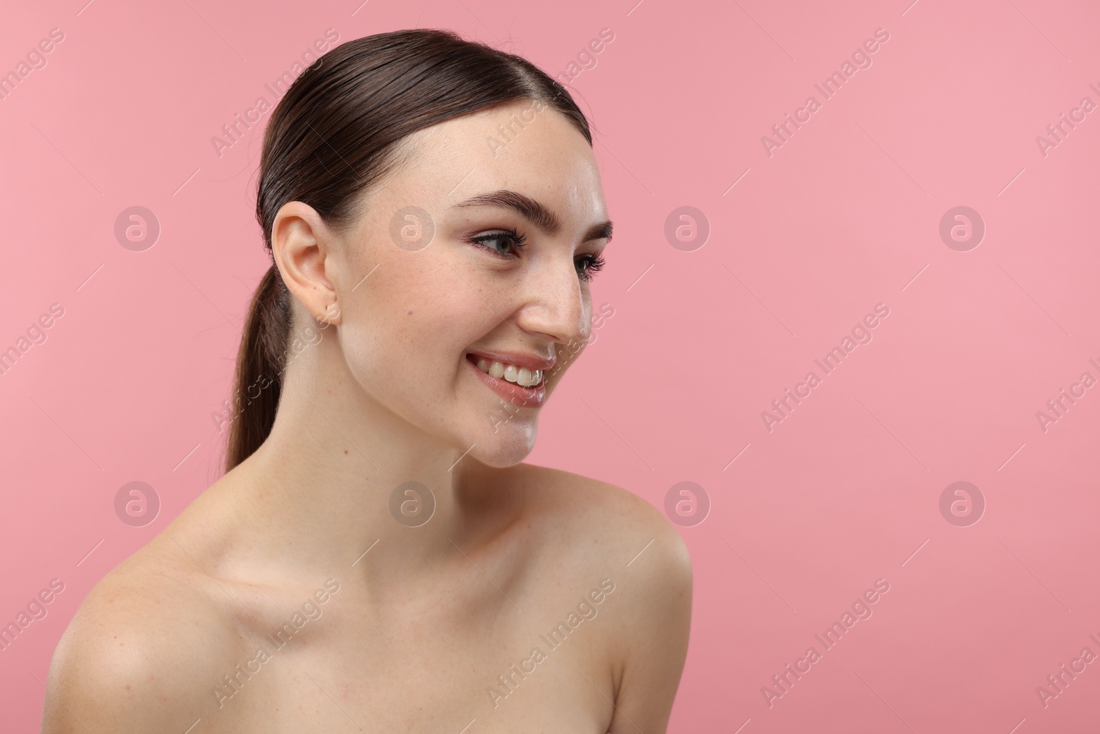 Photo of Portrait of smiling woman on pink background. Space for text