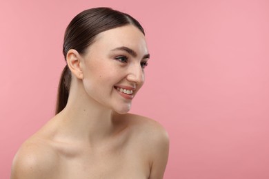 Portrait of smiling woman on pink background. Space for text