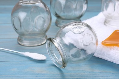 Photo of Cupping set on light blue wooden table, closeup