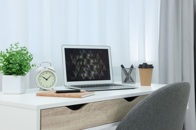 Photo of Workplace with modern laptop on desk at home