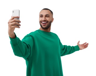 Photo of Smiling young man taking selfie with smartphone on white background