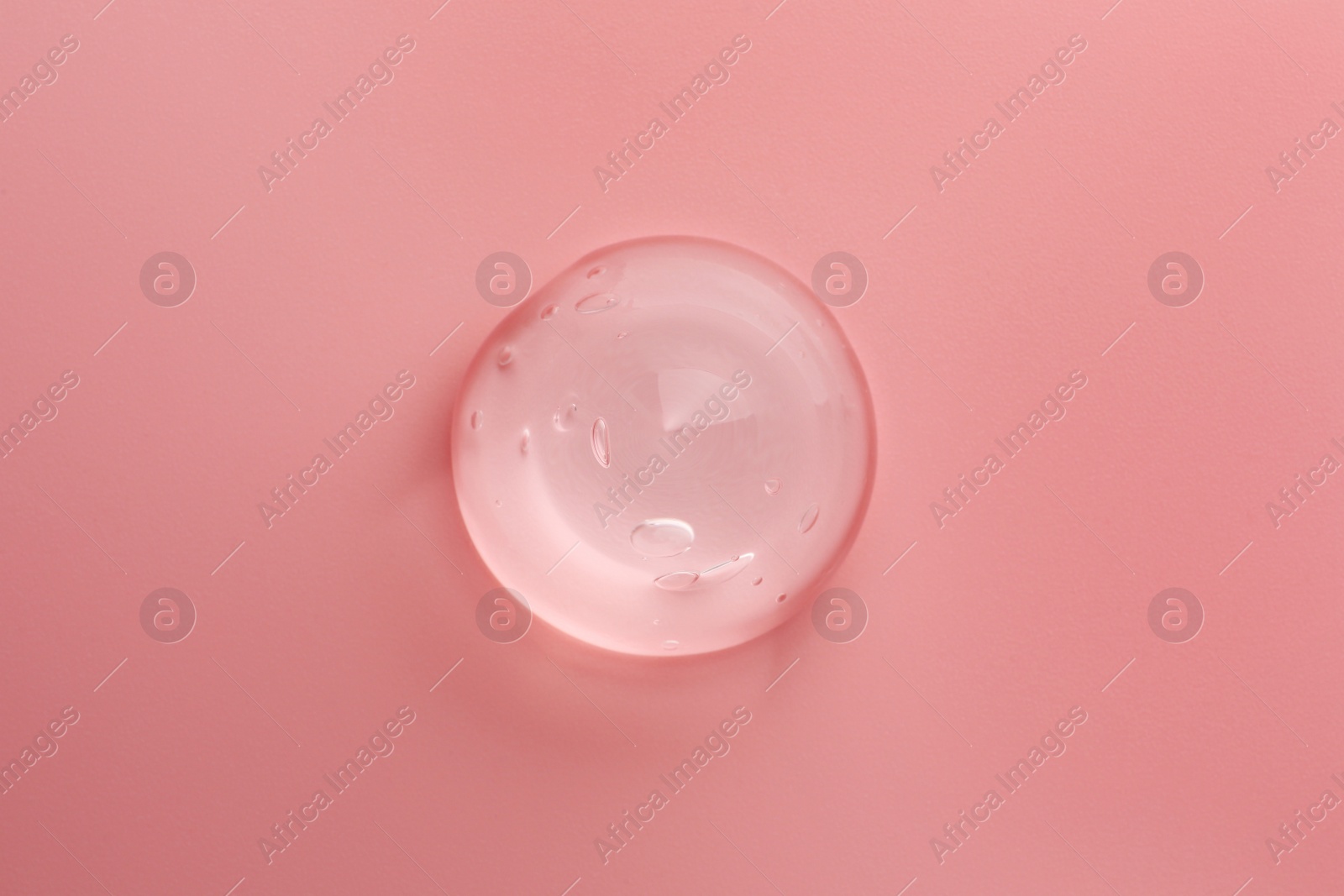 Photo of Sample of transparent gel on pink background, top view