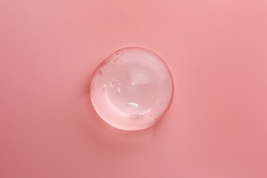 Sample of transparent gel on pink background, top view