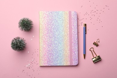 Bright planner, stationery and festive decor on pink background, flat lay. New Year aims