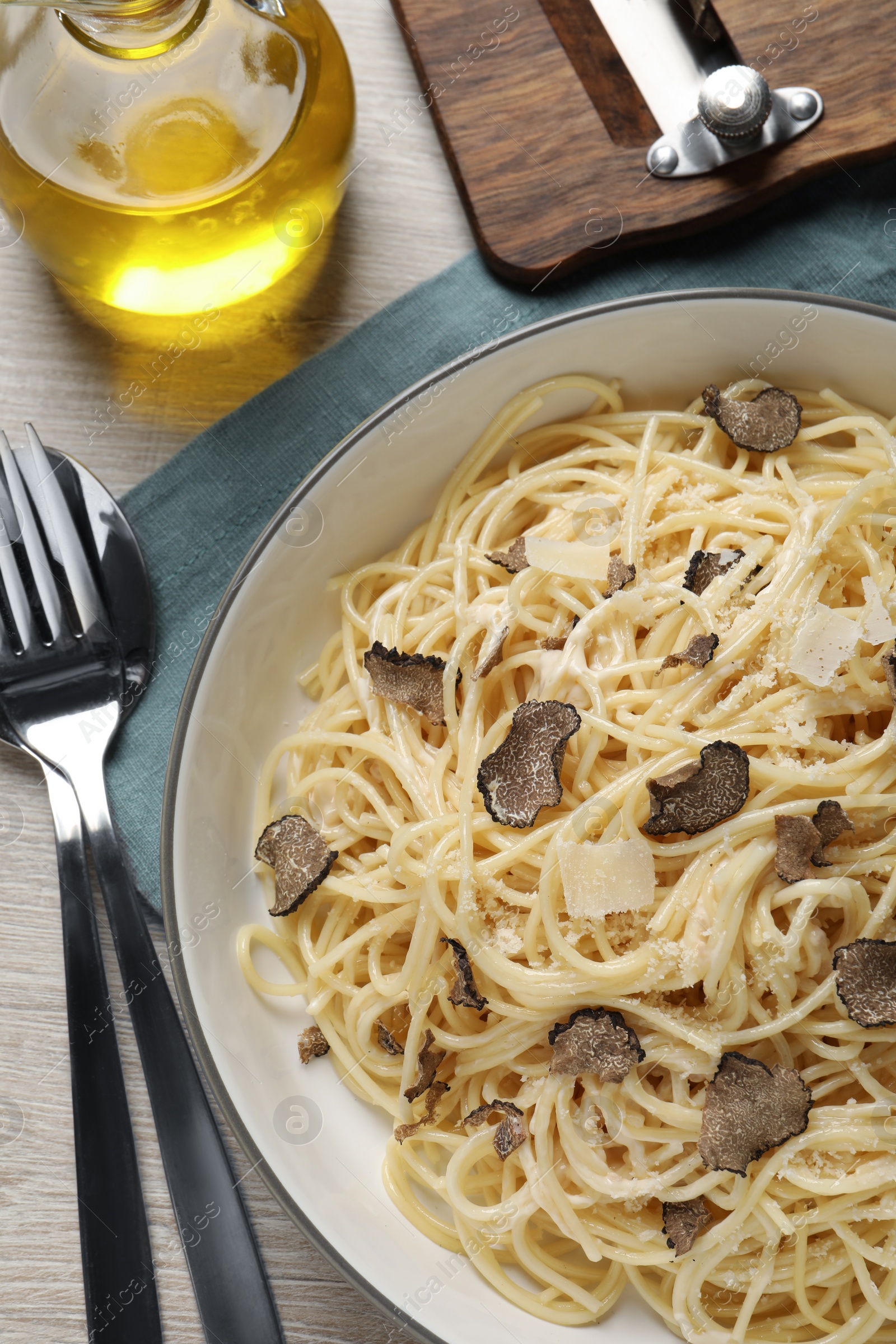 Photo of Tasty spaghetti with truffle served on wooden table, flat lay