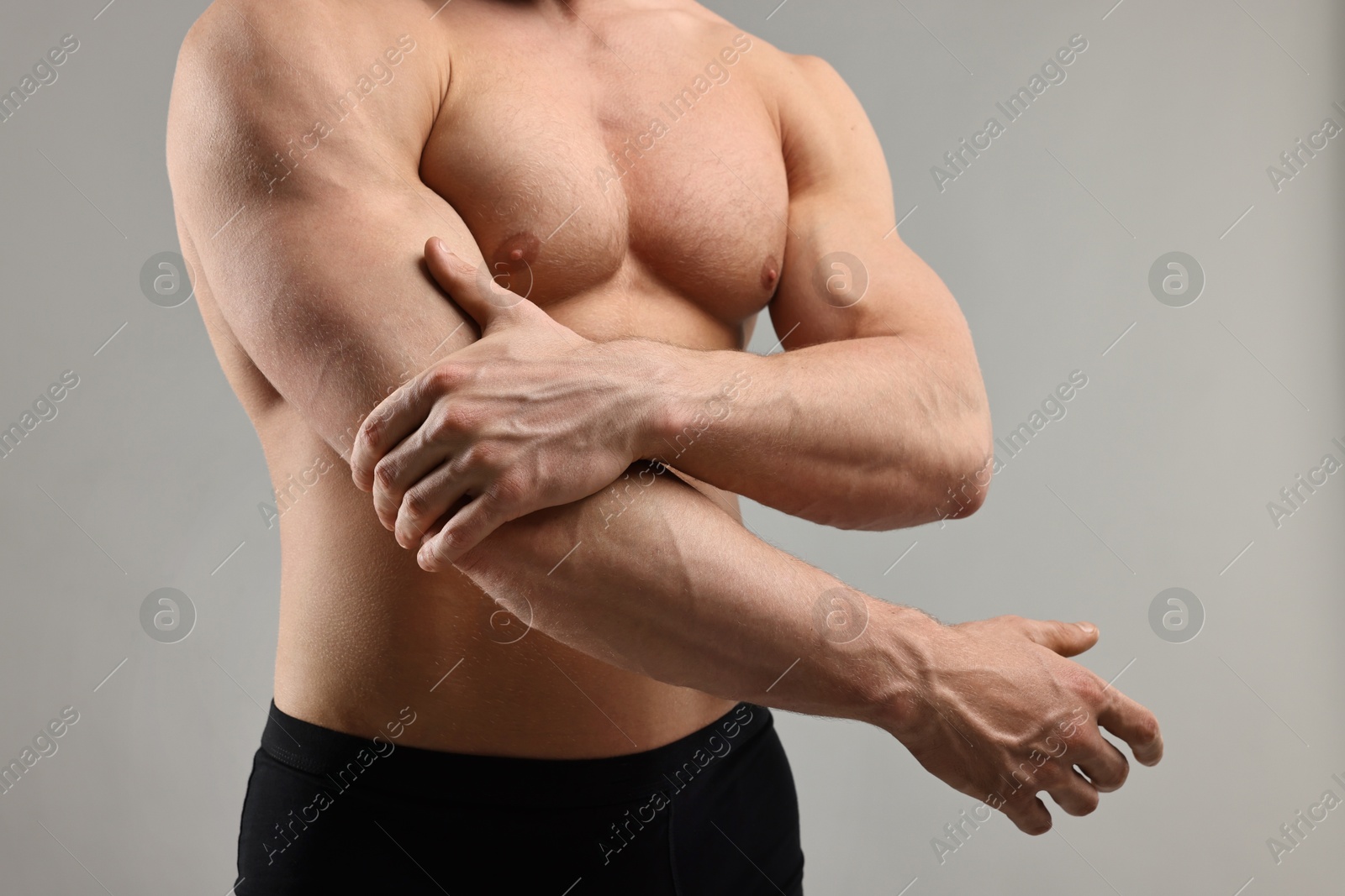 Photo of Man with muscular body on light grey background, closeup