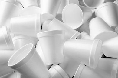 Photo of Heap of white styrofoam cups as background, closeup