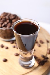 Photo of Shot glass of coffee liqueur on table, closeup