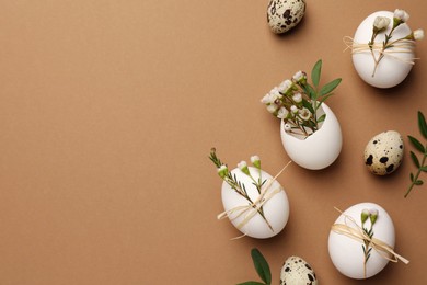 Photo of Happy Easter. Festive composition with eggs and floral decor on brown background, flat lay. Space for text.