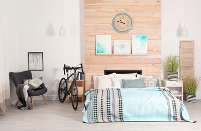 Photo of Modern apartment interior with bicycle near bed