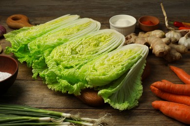 Cut fresh ripe Chinese cabbages and ingredients on wooden table