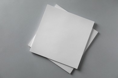 Stack of blank paper sheets for brochure on light grey background, top view