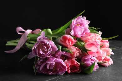 Photo of Beautiful bouquet of colorful tulip flowers on black table