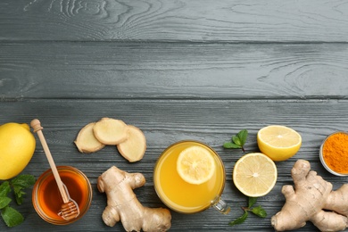 Photo of Flat lay composition with immunity boosting drink and ingredients on grey wooden table. Space for text