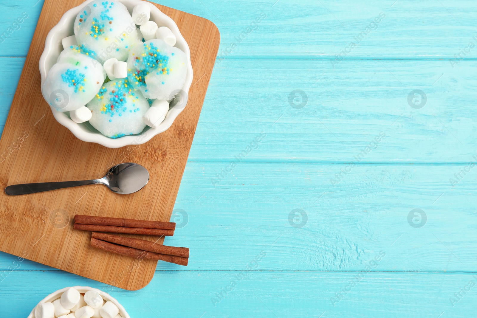 Photo of Flat lay composition with snow ice cream in bowl, marshmallows and space for text on color background