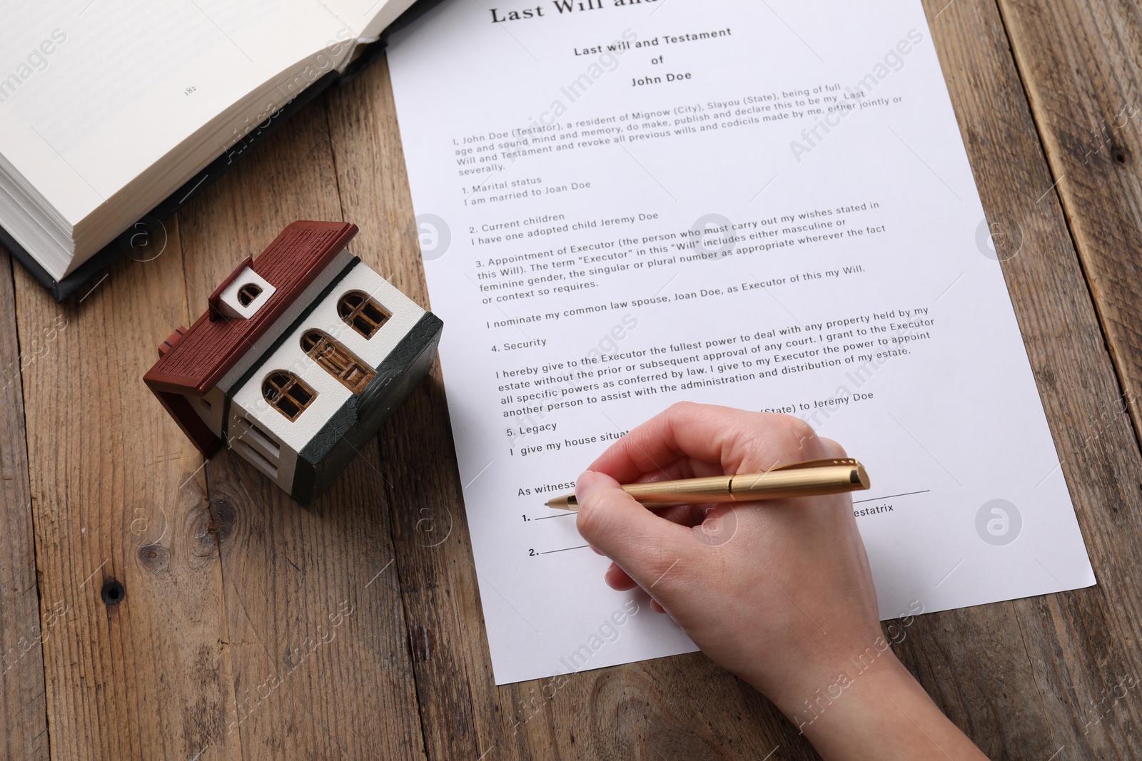 Photo of Woman signing Last Will and Testament at wooden table, above view