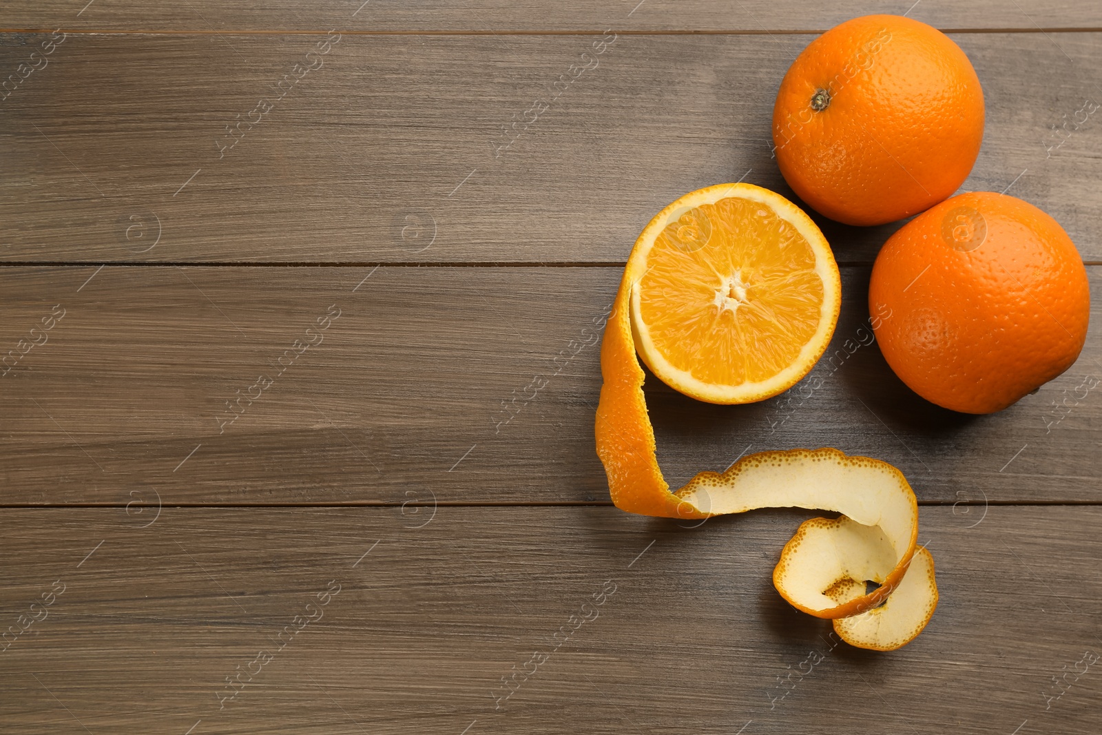 Photo of Orange fruits with peel on wooden table, flat lay. Space for text