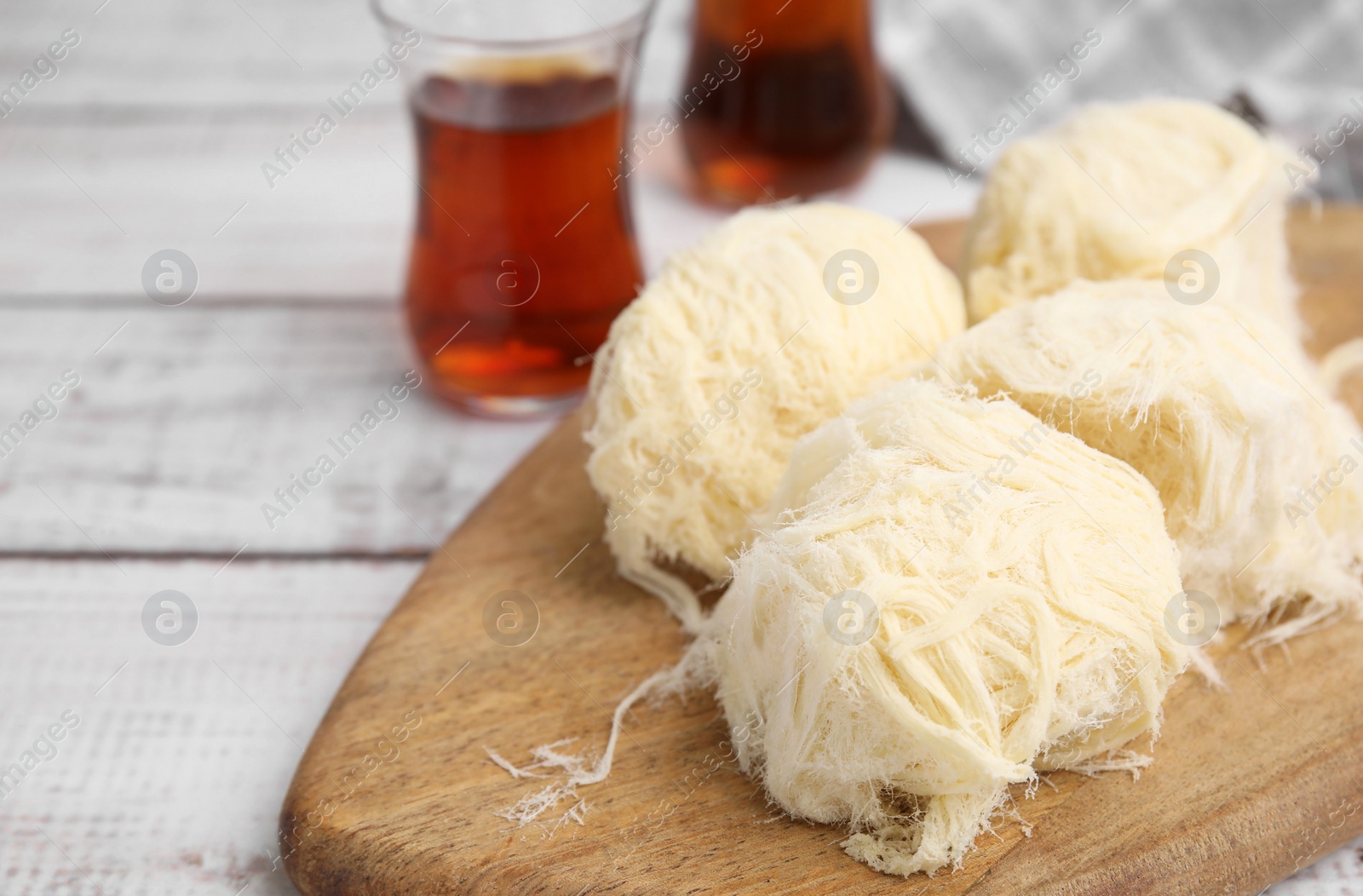 Photo of Eastern sweets. Tasty Iranian pashmak on white wooden table, closeup