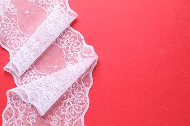 White lace on red background, top view. Space for text