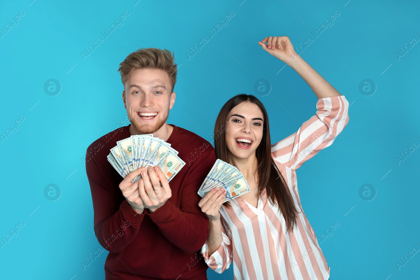 Photo of Young couple with money on color background