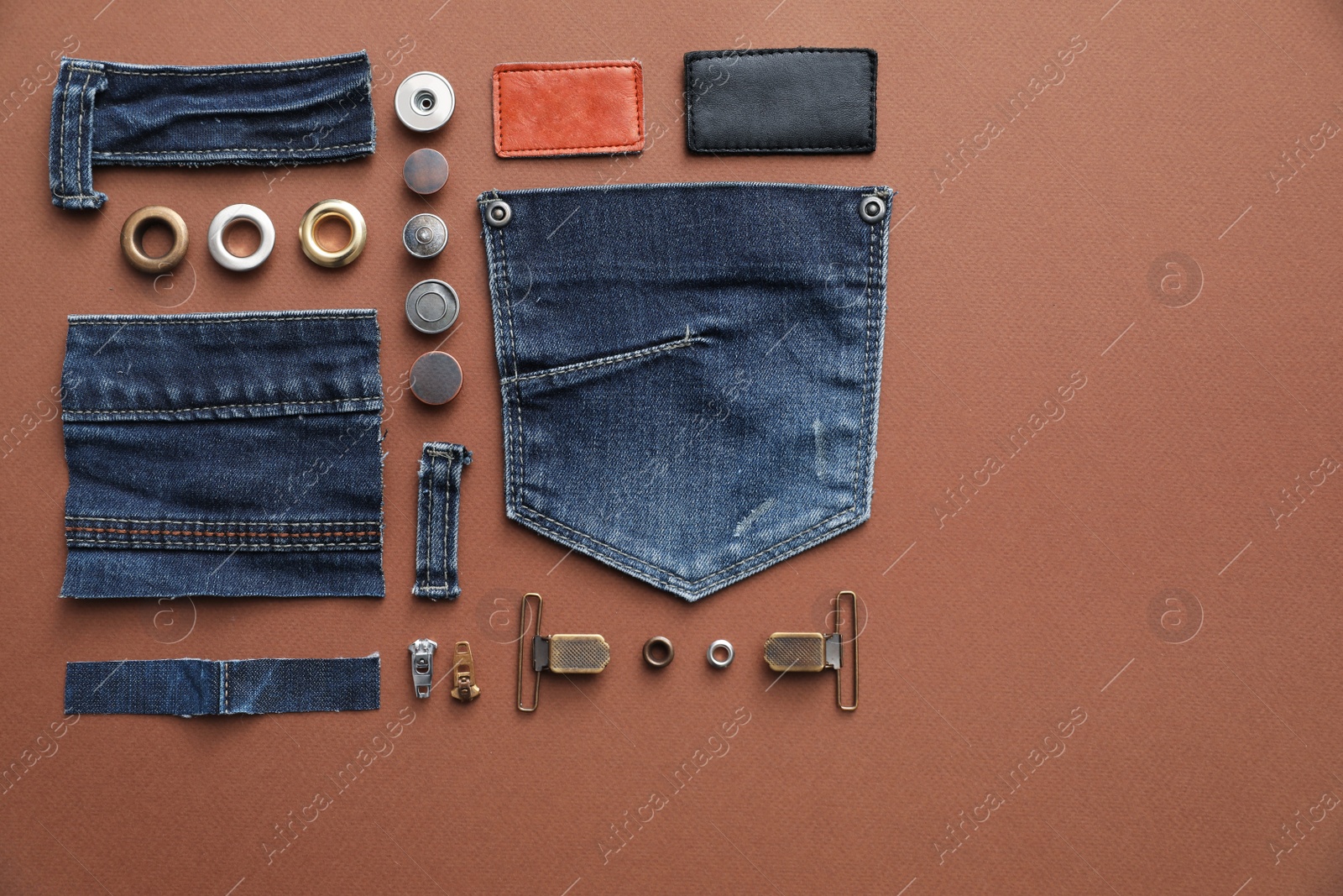 Photo of Flat lay composition with garment accessories and cutting details for jeans on brown background