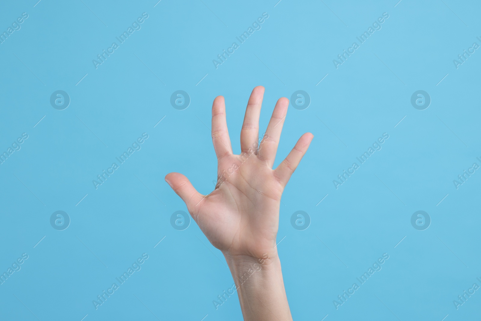 Photo of Woman giving high five on light blue background, closeup