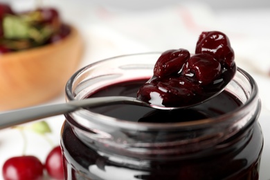 Photo of Jar of delicious pickled cherries, closeup view