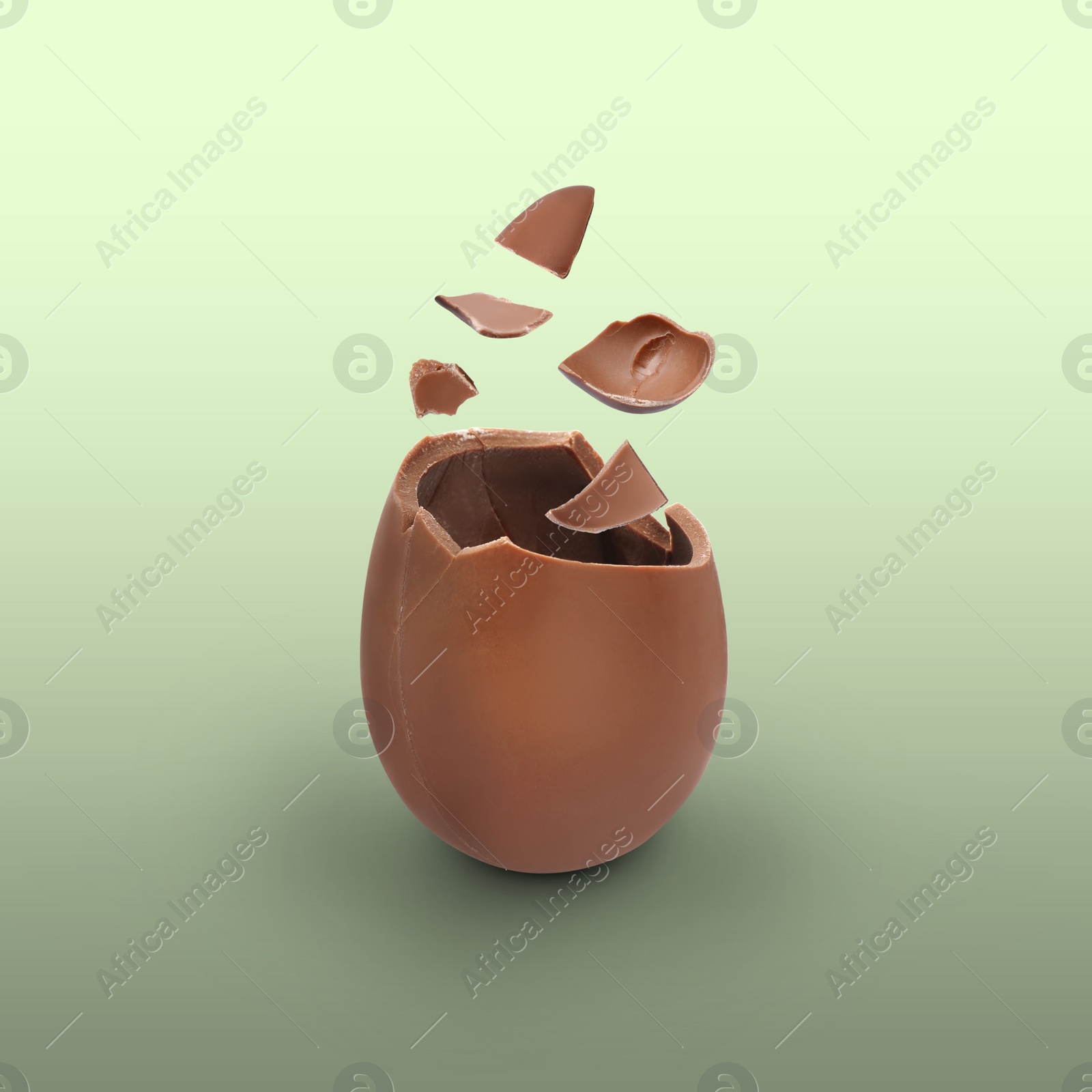 Image of Broken milk chocolate egg on color background