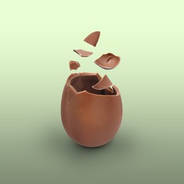 Broken milk chocolate egg on color background