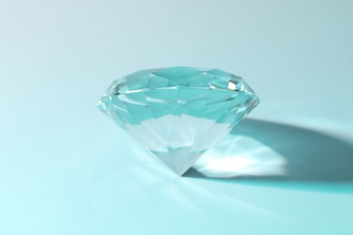 Beautiful dazzling diamond on light blue background