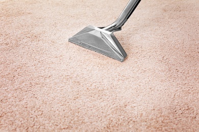 Photo of Removing dirt from carpet with professional vacuum cleaner indoors