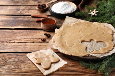 Making homemade Christmas cookies. Dough for gingerbread man on wooden table