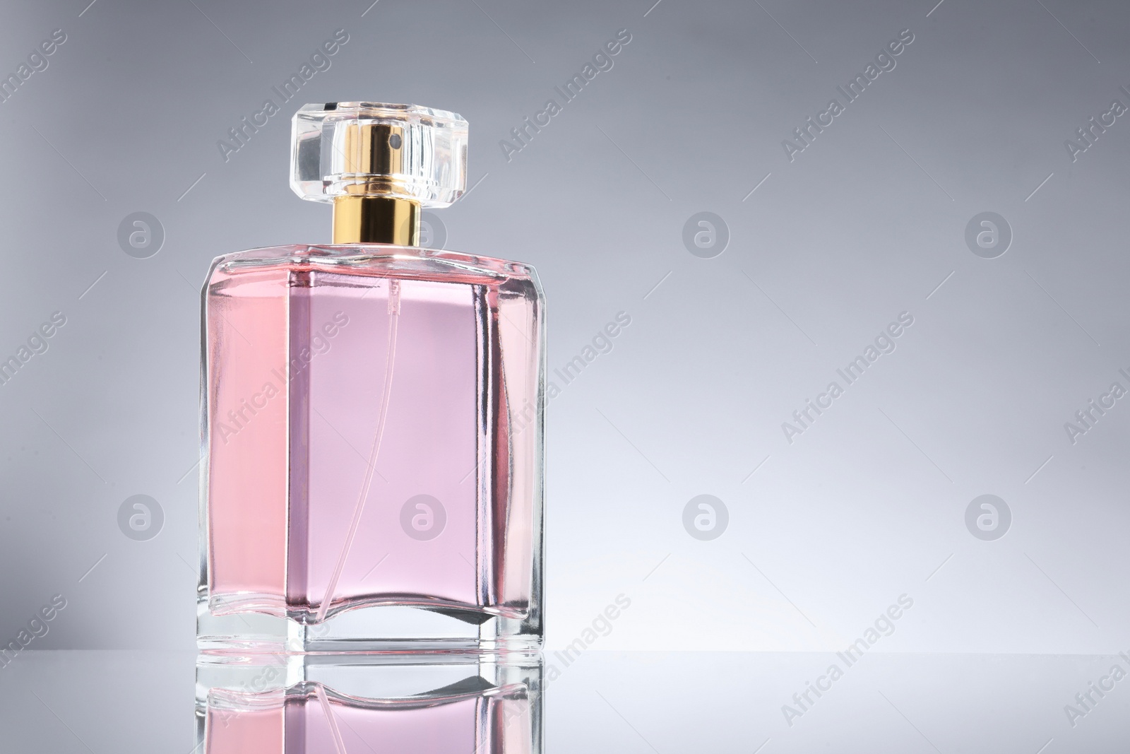 Photo of Luxury women's perfume in bottle on grey background. Space for text