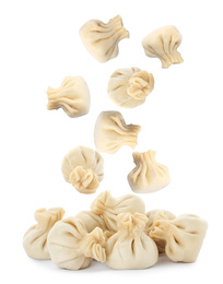 Many tasty dumplings falling on white background