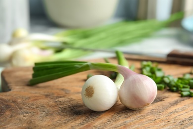 Photo of Fresh green onion on wooden board, closeup