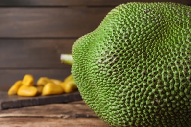Photo of Fresh exotic jackfruit on wooden table, closeup