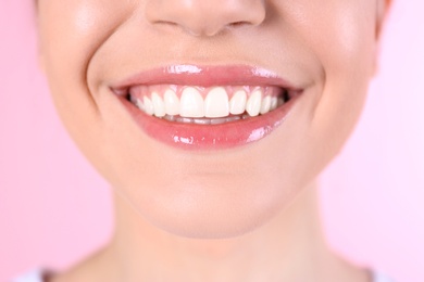 Photo of Young woman with healthy teeth and beautiful smile on color background, closeup