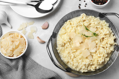 Photo of Delicious risotto with cheese on grey marble table, flat lay