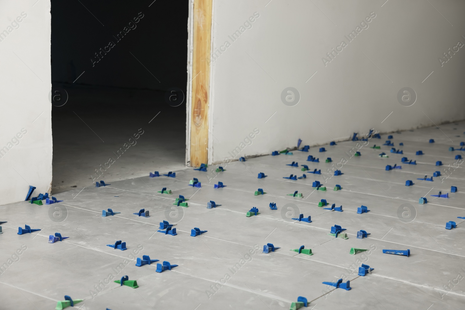 Photo of Beautiful tiles with colorful wedges on floor near wall