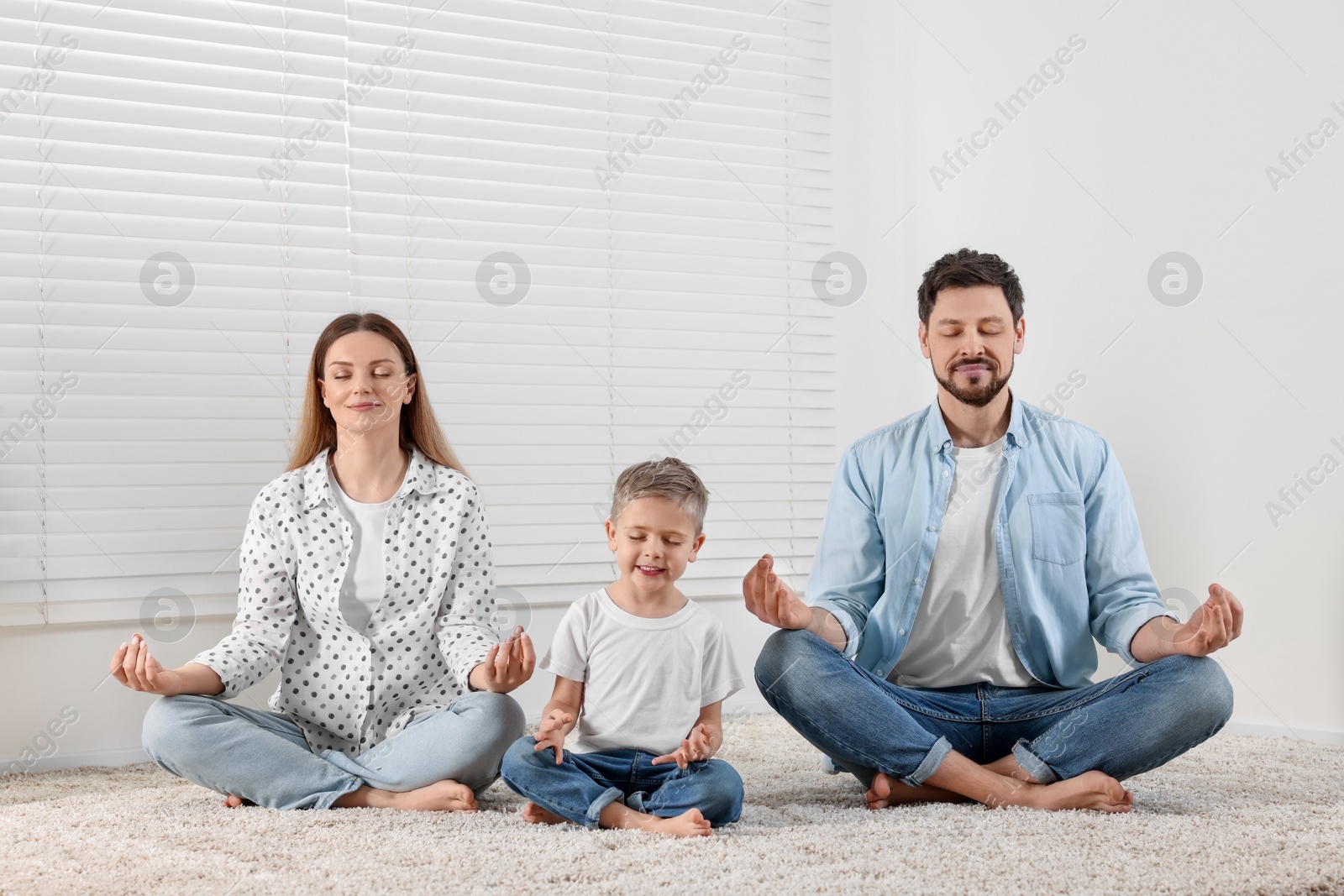 Photo of Family meditating together at home. Harmony and zen